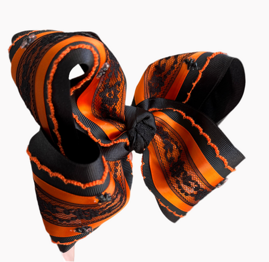Black and orange bow with lace details on a white background