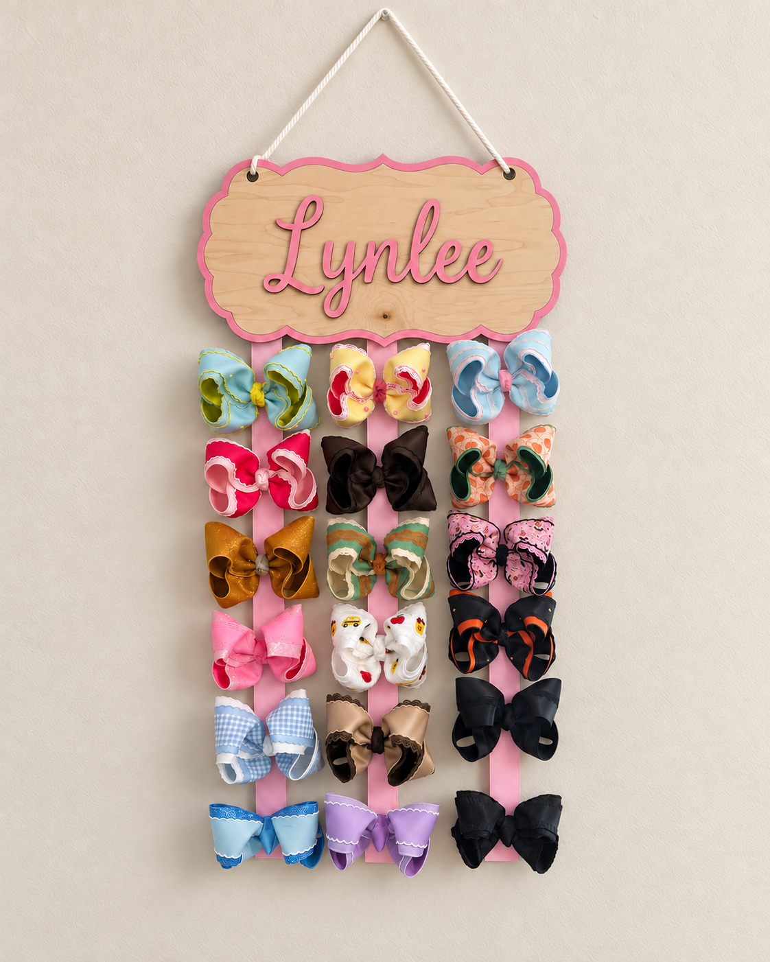 Personalized maple bow holder filled with large boutique bows on three spaced ribbons